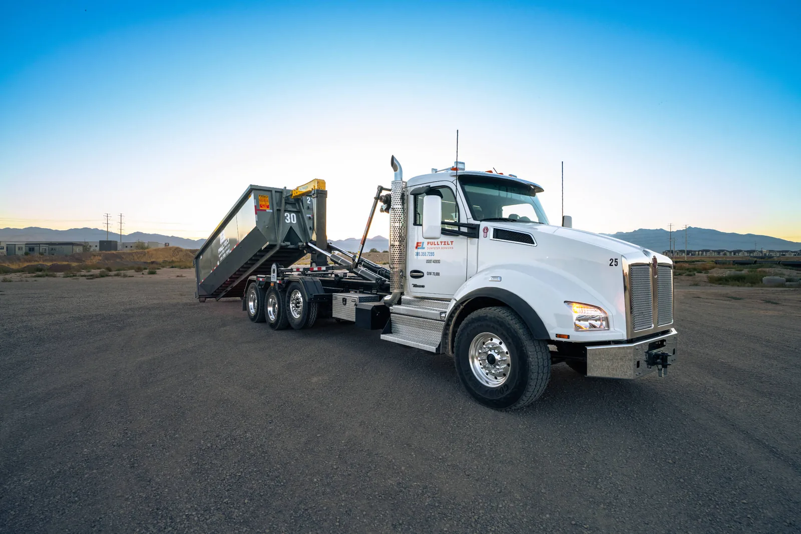 Full Tilt roll-off truck with its container loading equipment raised